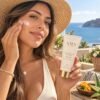 Woman applying AMA LUXURY Natural Mineral Sunscreen SPF 50 by the sea